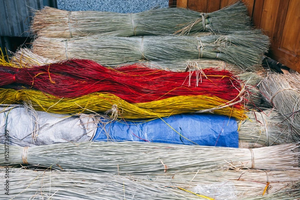 Fototapeta dry dyed reeds lie in piles at warehouse for production of traditional woven mats in a Vietnamese village in Vietnam
