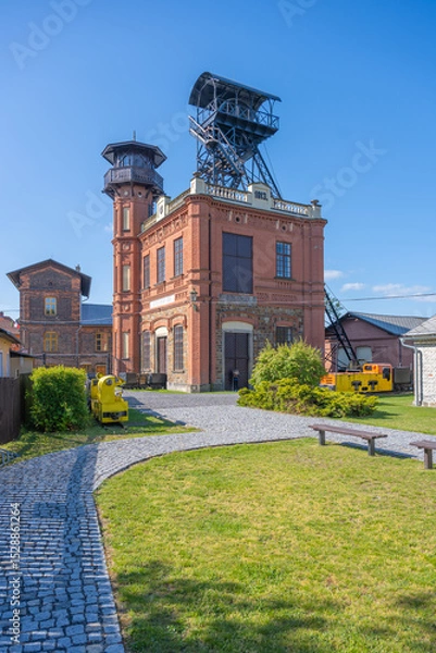 Fototapeta Sevcinsky mine in Brezove Hory showcases striking architecture and mining equipment. This historic site reflects the rich mining heritage of Czechia, inviting visitors to explore its past.