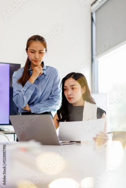 Obraz  Two business woman lawyer or company employee holding accounting bookkeeping documents checking financial data or marketing report working in office with laptop. Paperwork management
