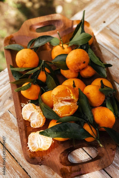 Fototapeta Ripe tangerines on the background of a wooden table. Assembled juicy tangerine in close-up. Delicious citrus fruits for juicing