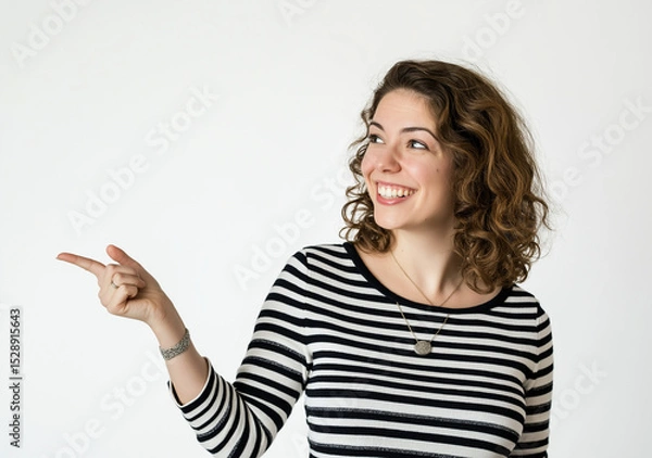 Fototapeta Happy Young Woman Pointing to the Side – Studio Portrait with Striped Top, Tattoo Detail, White Background, High-Resolution Stock Photo with Copy Space for Advertising and Marketing