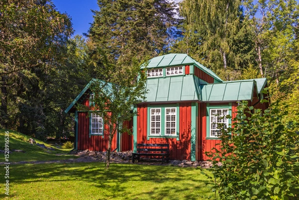 Obraz Idyllic red cottage with a beautiful sunny garden