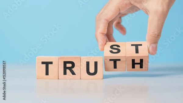 Obraz Hand flipping wooden cube with TRUST and TRUTH words. Concept of business ethics, honesty, integrity, and building trustworthy relationships. Clean table background