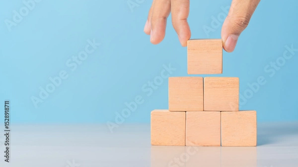 Obraz man is placing blank blocks in a row on the blue background