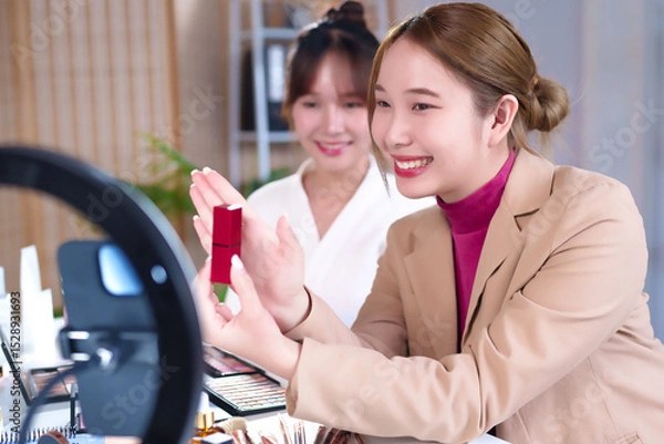 Obraz Asian Women Demonstrating Lipstick in Beauty Tutorial Video with Ring Light and Makeup Palette for Online Cosmetics Brand Promotion