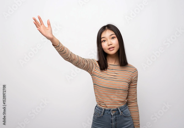 Fototapeta Full-Body Portrait of a Young Woman in Jeans and Striped Top – Artistic Pose with Open Palm and Raised Hand, White Background, Studio Shot, High-Resolution Fashion and Lifestyle Photography