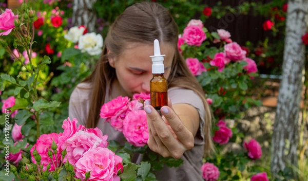 Fototapeta Allergy to flowers. Woman in the garden with a napkin allergy. Selective focus