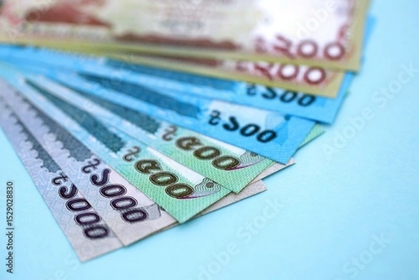Fototapeta Bangladeshi taka money bills in big amount lies on teal color table close up