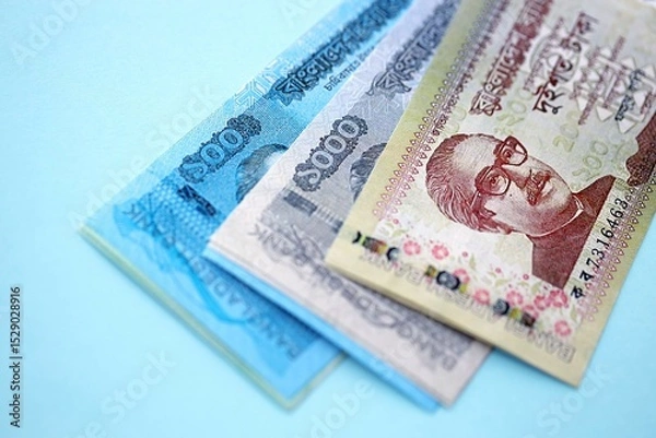 Fototapeta Bangladeshi taka money bills in big amount lies on teal color table close up