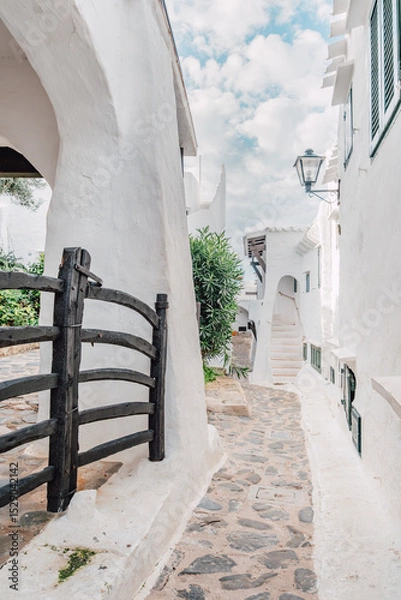 Fototapeta Picturesque Whitewashed Alley In Binibeca Vell With Traditional Menorcan Gate. Charming Coastal Village, Balearic Islands Architecture, Idyllic Scene