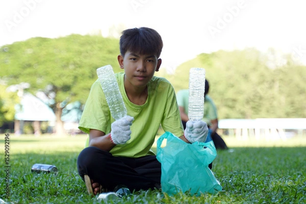 Fototapeta Asian boy is a student in the Environmental Club and his friends help collect and sort waste plastic water bottles and glass bottles for recycling or reuse. In the concept of saving the world.