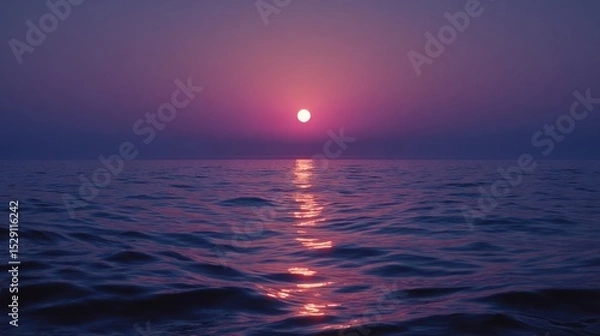 Fototapeta Sunset over water with reflection creating a path of light.