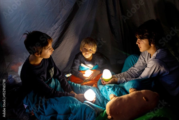 Obraz Children, siblings, enjoying a night in a tent in camping, laughing and reading books