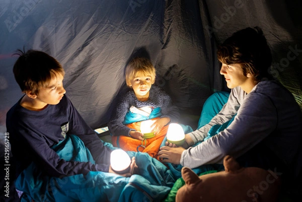 Obraz Children, siblings, enjoying a night in a tent in camping, laughing and reading books