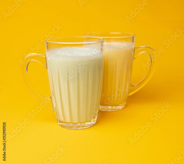 Obraz Vanilla milk shake in glass. Milkshake on yellow background, white whey protein smoothie