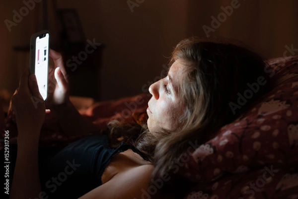 Obraz Depicts a common moment of sleeplessness due to smartphone overuse at night.