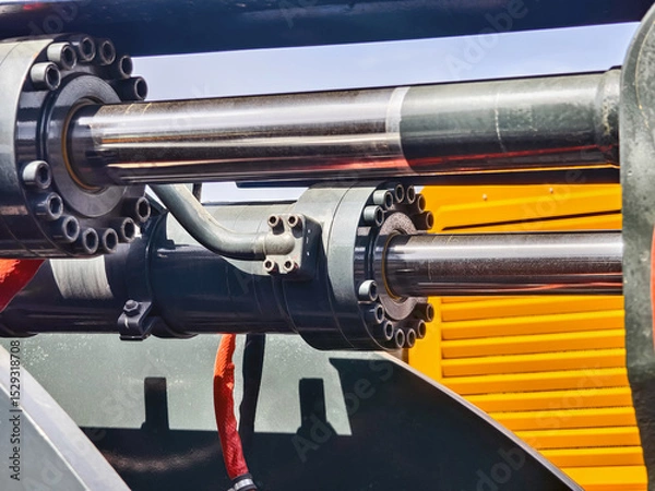 Obraz Hydraulic machinery components in a construction site during bright daylight