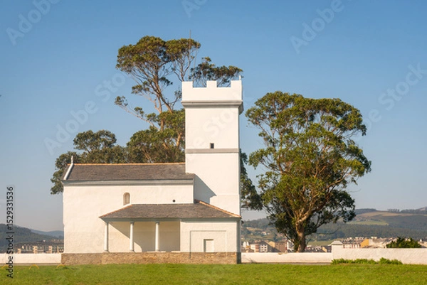 Fototapeta Chapel surrounded by lush greenery in Ribadeo Spain offers serene views in clear weather