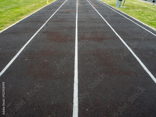 Fototapeta A track is shown with white lines and a black surface