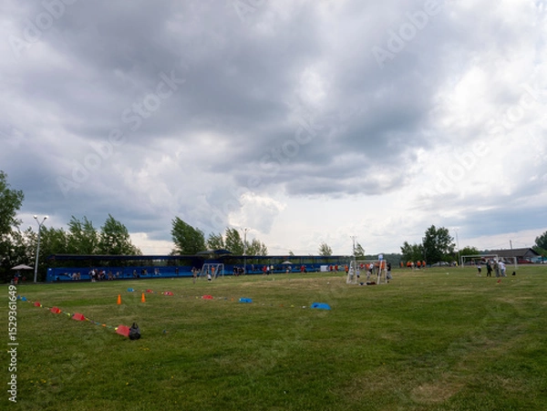 Fototapeta A group of people are playing soccer in a field