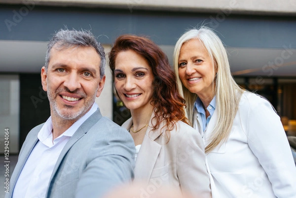 Fototapeta Selfie of three business professionals collaborating on a project outside the office