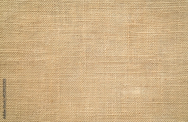 Fototapeta Beige linen background featuring a natural woven texture, perfect for use in decorative projects and design layouts. The burlap-style fabric adds a soft, rustic visual appeal