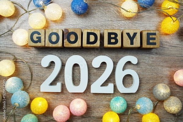 Fototapeta Goodbye 2026 years number with LED cotton balls decoration top view on wooden background