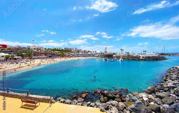 Obraz View of Playa La Pinta in Puerto Colon small beach with volcanic sand,calm waves and transparent water in Tenerife,Canary islands,Spain.