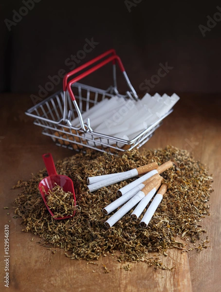 Fototapeta Tobacco heap with cigarettes, pile of tubes for make own cigarettes in a shop basket - concept about the underground cigarettes manufacture, counterfeit or alternative of legal tobacco products.