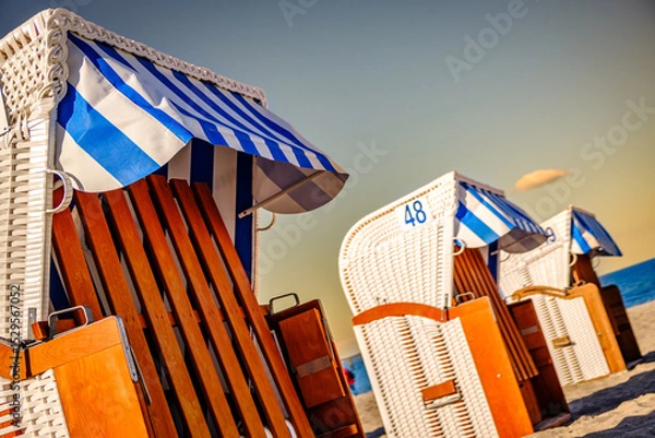 Fototapeta Beachside cabins lined on a sunny day showcasing vibrant colors and clear skies in a coastal location
