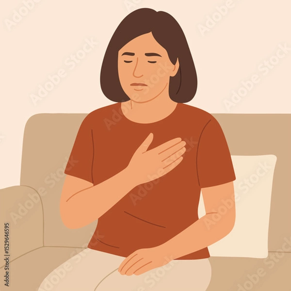 Obraz A woman with chest pain is sitting on the couch.