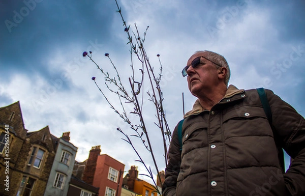 Obraz portrait of a senior man  against a storm sky in Oxford 