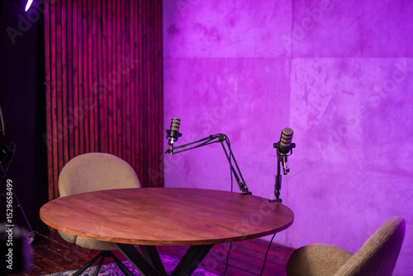 Fototapeta Podcast studio setup with two microphones and cozy chairs designed for engaging broadcasts and discussions