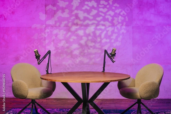 Fototapeta Podcast recording setup with modern chairs and microphones illuminated by colorful lights