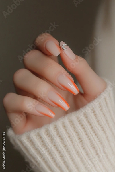 Obraz Modern and minimalist touch: Hand with almond-shaped nails, featuring a nude design with vibrant orange tips and a delicate crescent-shaped applique. Ideal for beauty themes, nail art trends and conte