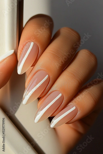 Obraz Hand with almond-shaped nails, featuring a minimalist design with white lines on a nude base. Ideal for beauty themes, nail art trends, sophistication and self-care.