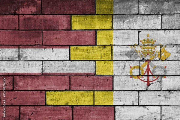 Fototapeta colourful painted big national flag of vatican city and flag of latvia on a massive old brick wall background. concept