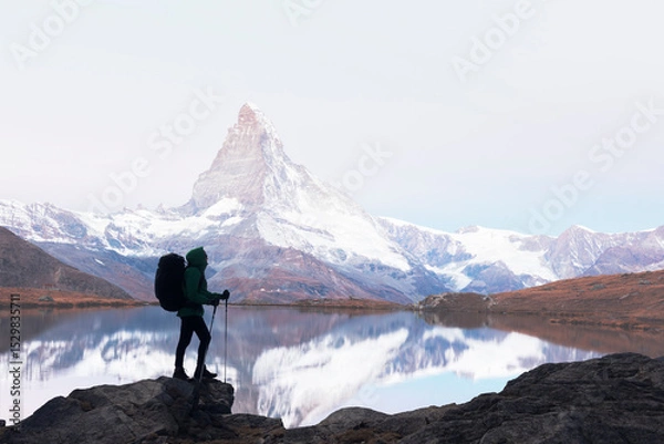 Obraz Silhouette of a tourist with a backpack against the background of Matterhorn peak and Stellisee lake in Swiss mountains. Travel and adventure concept