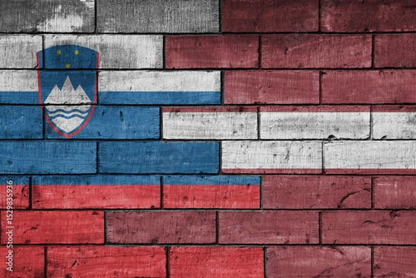 Fototapeta colourful painted big national flag of latvia and flag of slovenia on a massive old brick wall background. concept