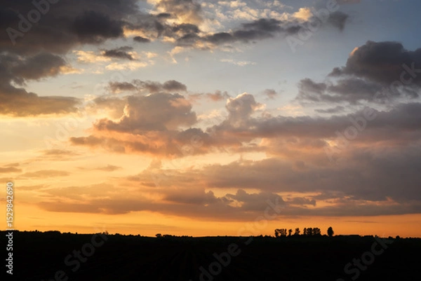 Obraz Incredible sunset with dramatic clouds and warm golden light in evening sky