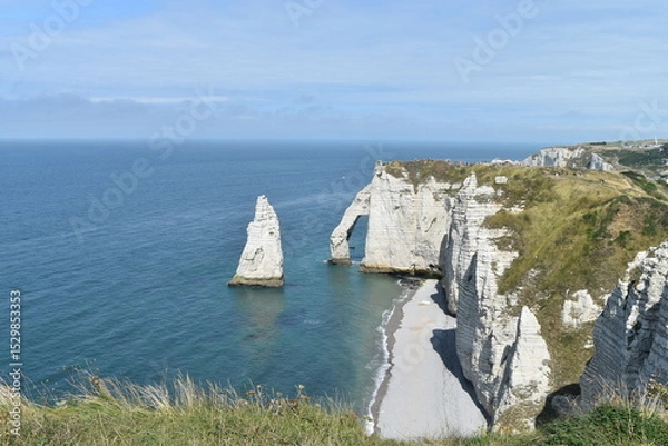 Obraz Plage et falaises d'Étretat, avec un rocher dans l'eau en forme de dent de requin.