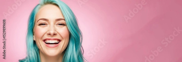 Fototapeta Bright smile captured with vibrant blue hair against a soft pink backdrop creating a joyful and lively atmosphere