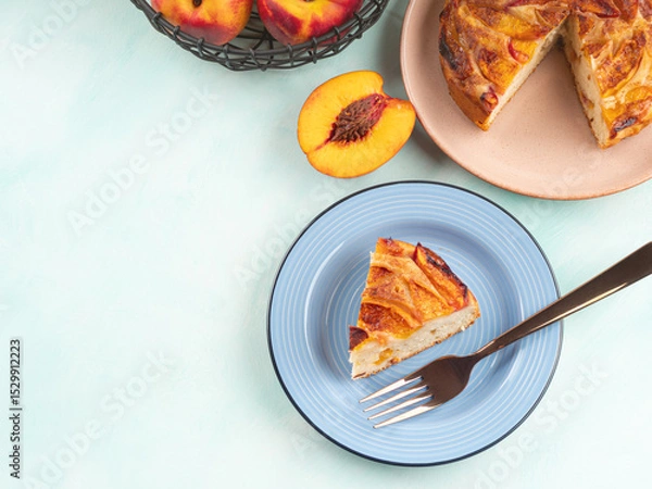 Fototapeta Piece of nectarine peach cake on turquoise table