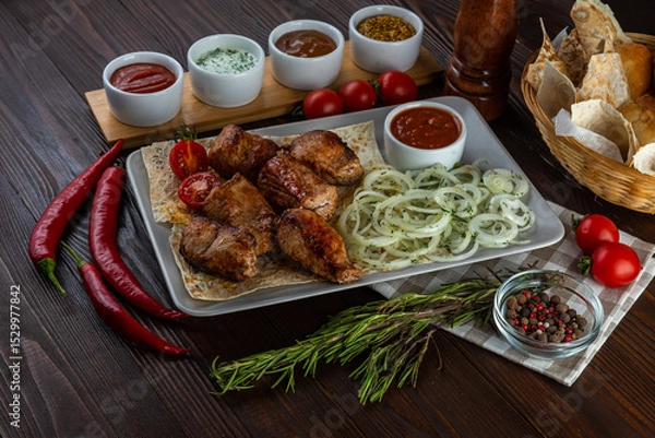 Fototapeta Shashlik with sauces and fresh bread on wooden background
