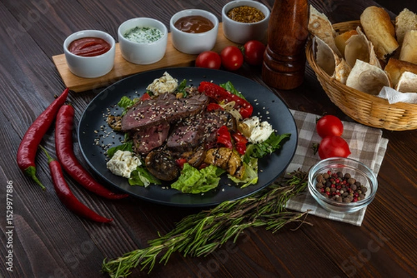 Fototapeta Warm salad with duck and sauces on wooden background