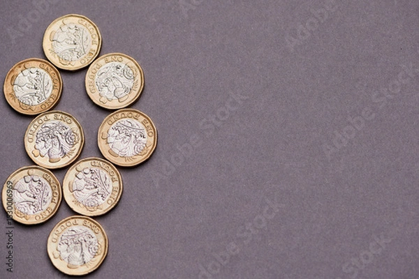 Fototapeta one pound notes arranged neatly on a gray background.