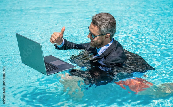 Obraz Freelance man has online video call. Freelance working online. Man using laptop for freelancing in swimming pool. Business freelancing. Businessman on summer vacation. Businessman on video conference