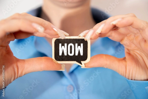 Fototapeta girl holding a card with the text WOW