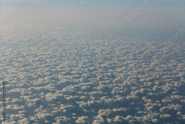 Fototapeta Stratosphere, view of water through clouds. Seascape, view from above, from an airplane window.