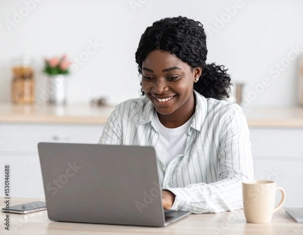 Fototapeta Person working on laptop with coffee beside, remote work setup